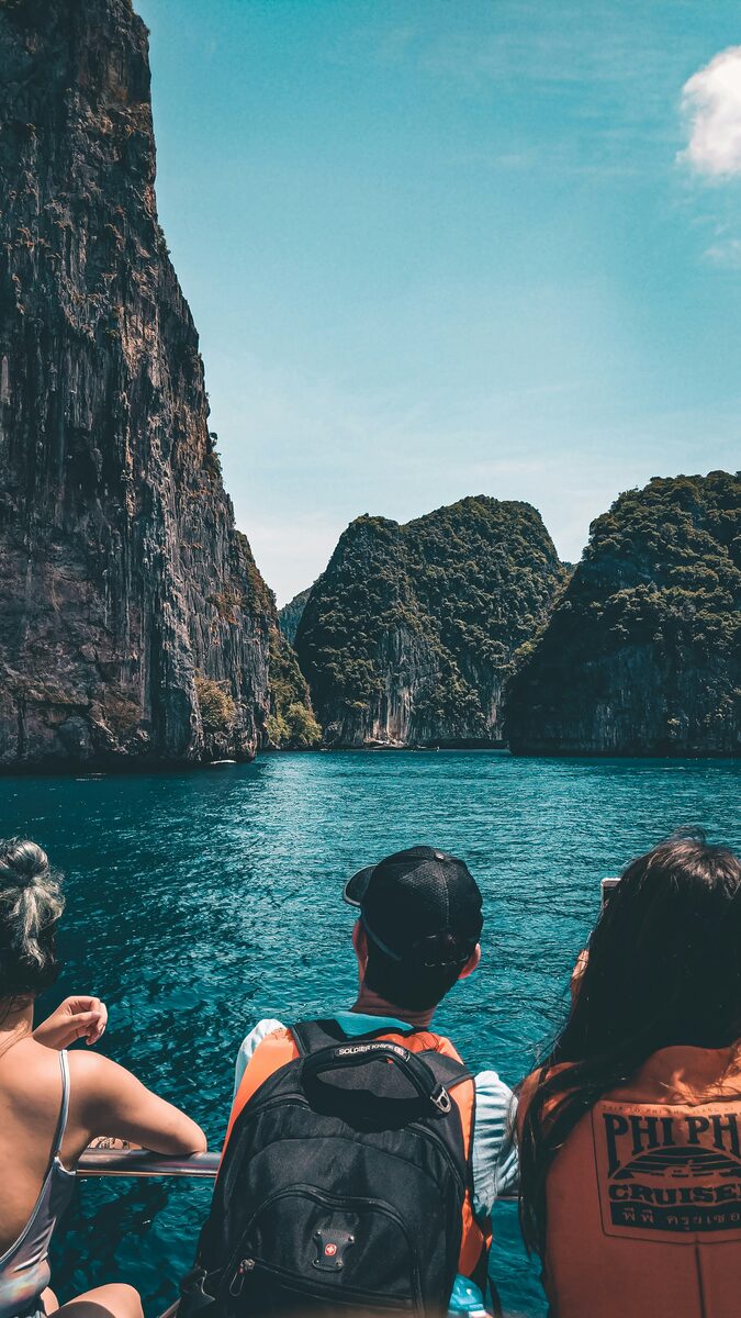 Scenic mountain road above a turquoise lake with a tour boat